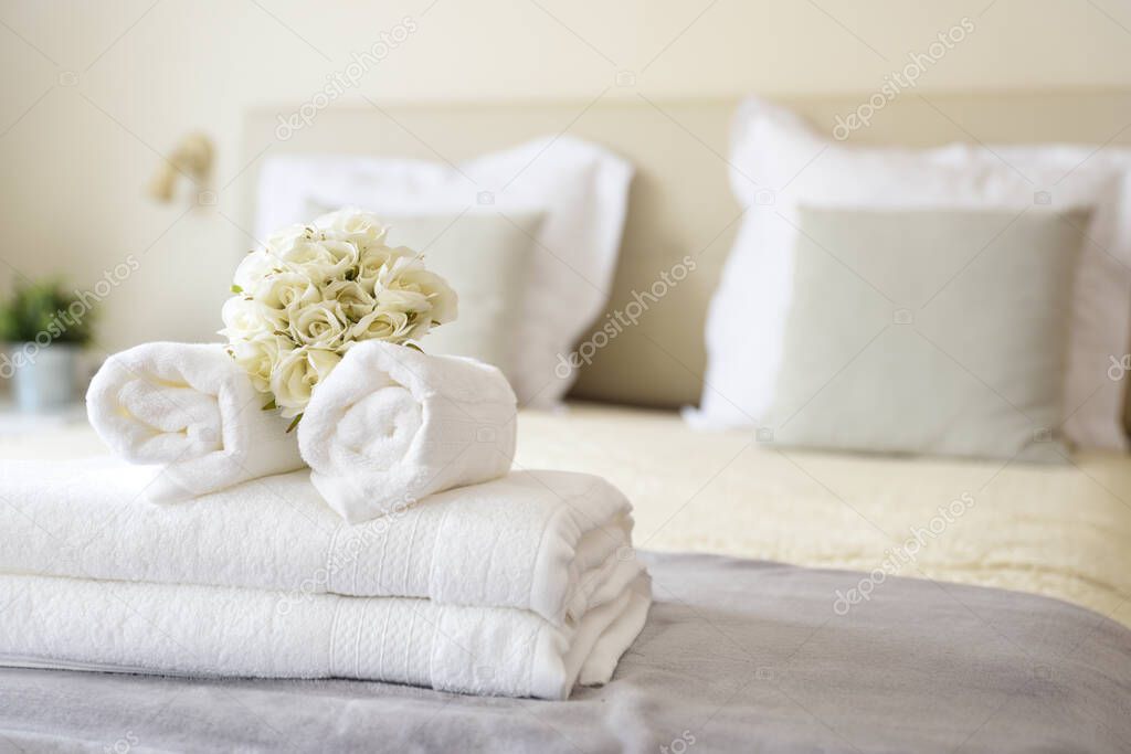 Set of clean white towels on bed in hotel room. Room service concept