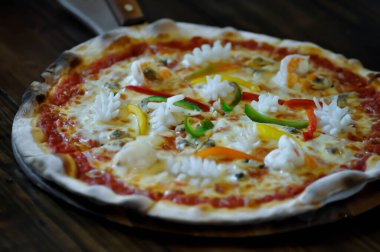 Pizza, ahşap tepside deniz ürünleri pizzası.