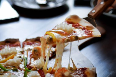 Kepçeli pizza, ahşap tepside pizza.