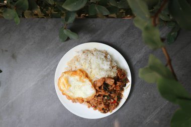 Yumurta ve kızarmış parkı acı biber ezmesi ve pilavla karıştırın.