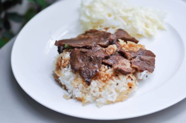 Izgara domuz eti ya da pirinçli kızarmış domuz eti.