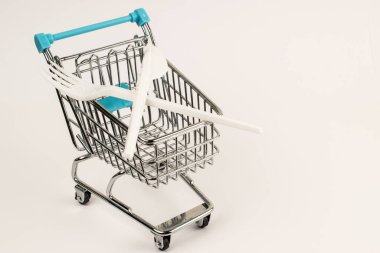 Plastik tabakları durdurun. Beyaz izolasyondaki bir süpermarketin arabası. Plastik çatal ve bıçak..