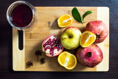Meyve dolu bir hayat. Garnet tahtada kesiliyor. Portakal bir mutfak tahtasının üzerinde kesilmiş. Bir bardak nar suyu..