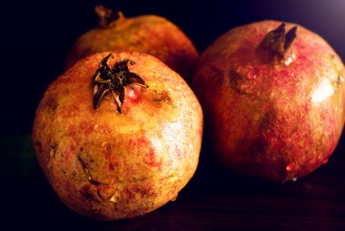 Tahta bir masada doymuş kırmızı nar..