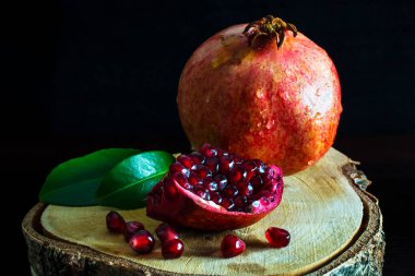 Ahşap bir stantta kırmızı nar kes. Sulu nar meyveleri..