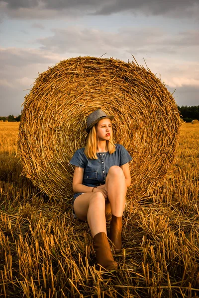 Una Chica Está Sentada Junto Pajar Vaquero Sonríe Mientras Mira —  Fotos de Stock