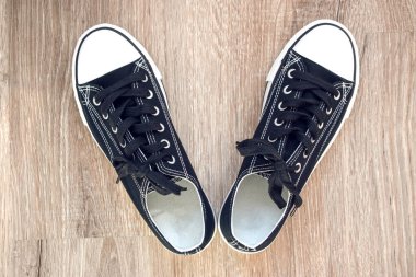 Yerde bir çift siyah beyaz spor ayakkabı..