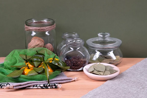 Mandarinas y ropa de cama, bolsas reutilizables con frascos de vidrio y plato de madera . — Foto de Stock