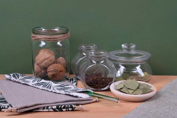 Bolsas de tubo y lino de vidrio con nueces y hojas de laurel . — Foto de Stock