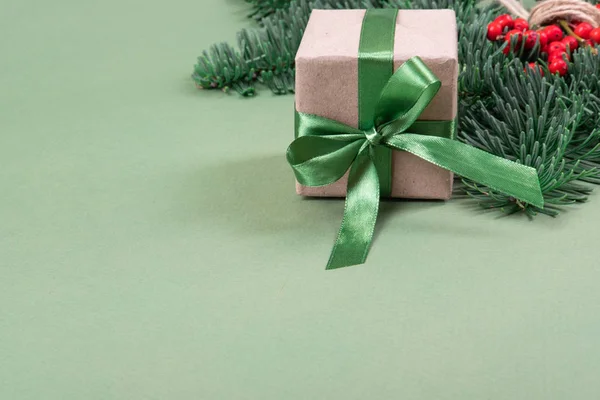 Vánoční dárek se zelenou stuhou a borovicovou větví. — Stock fotografie