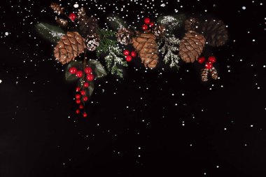 Altın çelenk ve karlı Noel süsleri.