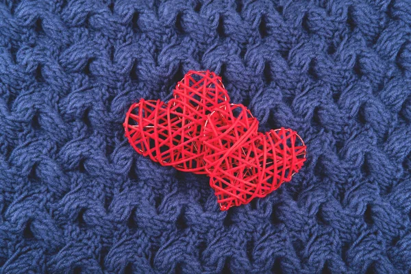 Mavi örgü arka planda iki kırmızı kalp. — Stok fotoğraf
