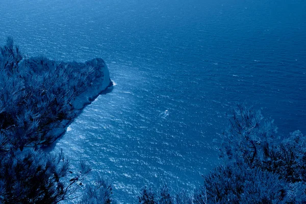 Yılın klasik mavi renginde bir gemiyle bir kayanın üstünden deniz manzarası.. — Stok fotoğraf