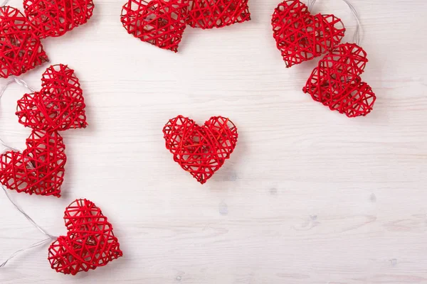 Luces rojas en forma de corazones sobre el fondo de madera . — Foto de Stock