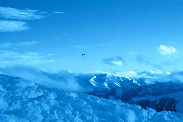 Mountain view with paraglider in the sky in the trendy classic blue color of the year. — Stock Photo, Image