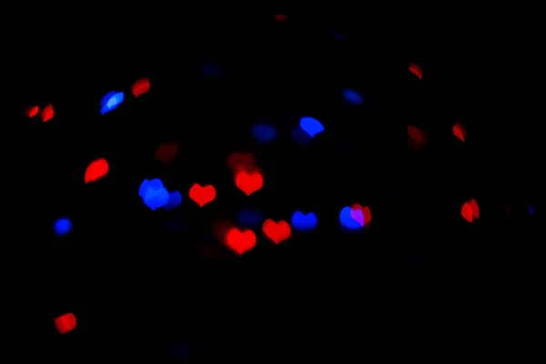 Red and blue lights in the shape of the hearts on the black background. — 스톡 사진