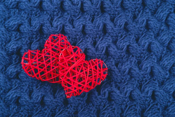 Two red hearts on the blue knitted background. — Stock Photo, Image