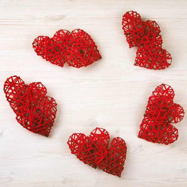 Composition of red wicker hearts on the wooden background. — ストック写真