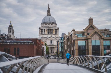 St Paul's Cathedral and Millennium Footbridge. Athlete train in  clipart