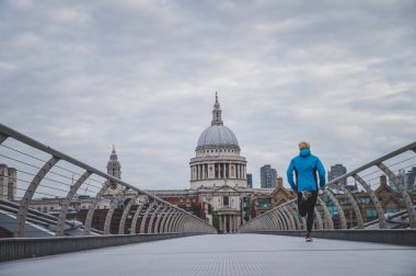 Londra maratonu konsept fotoğrafı. Millennium Footbridge 'de koşucu eğitimi, arka planda St Paul Katedrali.