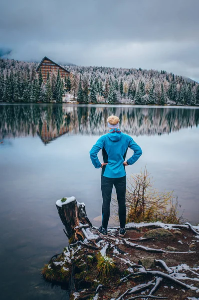 Ο άνθρωπος στέκεται δίπλα στη λίμνη το χειμώνα, σπορ ταπετσαρία. — Φωτογραφία Αρχείου