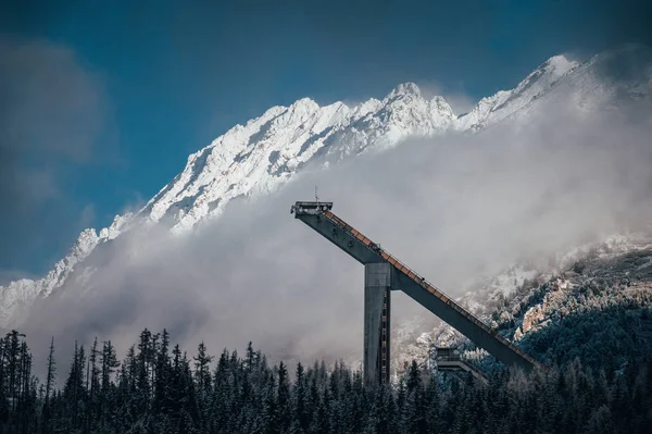 Kayakla atlama silueti, arka planda kışın beyaz karlı dağlar. Yüksek Tatras, Slovakya — Stok fotoğraf