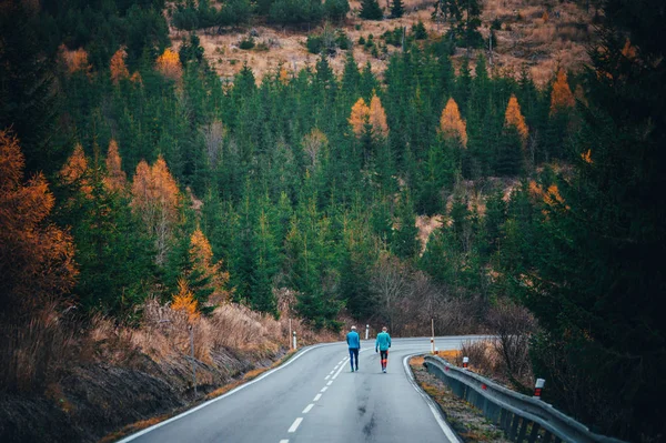 Trening grupowy, sportowcy spacerujący razem po drodze podczas jesiennego treningu — Zdjęcie stockowe
