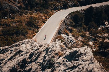 Mallorca İspanya, Sa Calobra 'da bisiklet süren bir adam var.