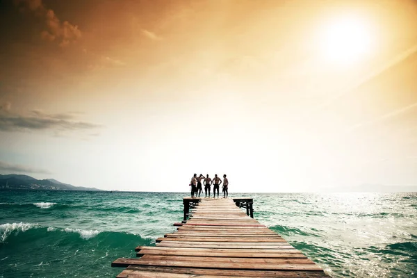 Eine Gruppe Taucher auf dem Pier im Sonnenuntergang. — Stockfoto