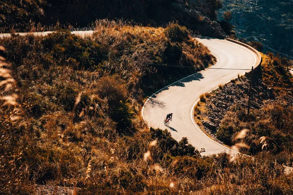 Small silhouette of rider on road bicycle, downhill on Sa Calobra, Mallorca — ストック写真