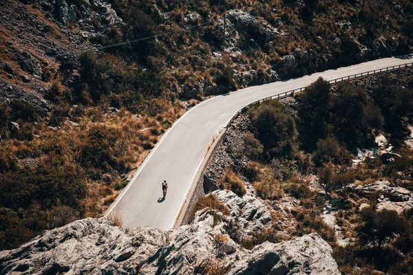 Silueta del ciclista en bicicleta de carretera, montar colina abajo en las montañas — Foto de Stock
