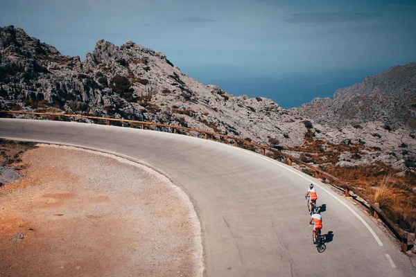 Homme et femme montent ensemble à vélo dans les montagnes, Couple actif sur la route . — Photo