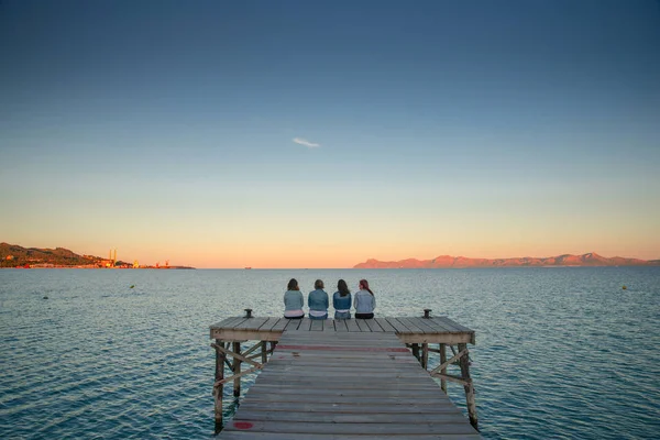 Frauen ruhen sich an Sommerabenden auf der Seebrücke aus. Mallorca, Spanien. Sommerurlaub mit Freunden — Stockfoto