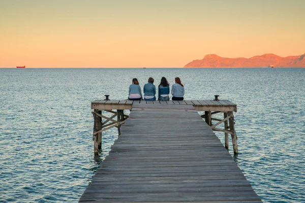 Donne sedute sul molo e che parlano insieme. Maiorca, Spagna. vacanza estiva con gli amici — Foto Stock