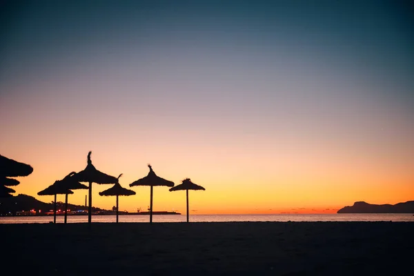 Силуэт Соломенных зонтов на тропическом пляже — стоковое фото