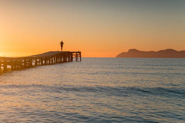 Silhouette des Läufers auf der Seebrücke beim morgendlichen Lauftraining am Meer. — Stockfoto