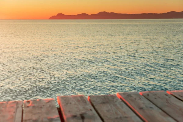 Warmes Morgenlicht im Sommerferienort. Pier in orangefarbenen Sonnenaufgangsfarben — Stockfoto