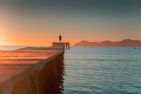 Sportlerlauf auf der Seebrücke am schönen goldenen Sommermorgen — Stockfoto