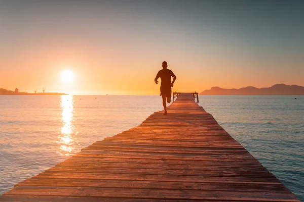 Morgentraining. Läufer trainieren bei schönem Sonnenaufgangslicht. Sportfoto. playa de muro — Stockfoto