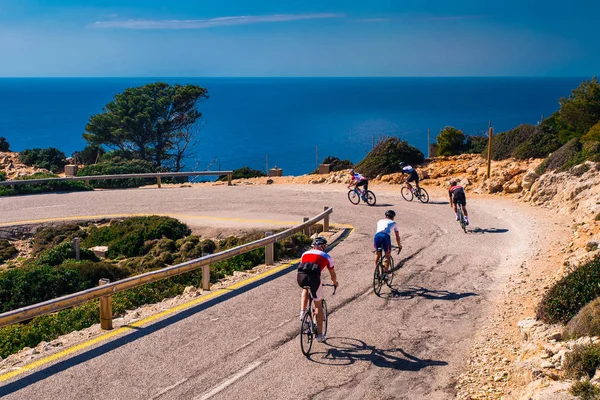 海沿いの道路自転車に乗ってアスリート。チームワーク、美しい自然の中でのスポーツ. — ストック写真