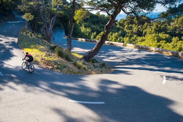 ロードサイクリングスポーツ写真。緑の夏の自然の中で自転車に乗る男 — ストック写真