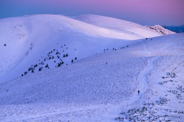Kış manzarası, karla kaplı dağlar, gökyüzünde pembe ve mavi renkler