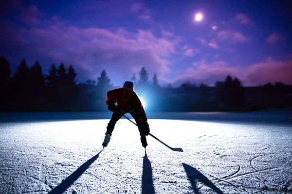 Hockey player silhouette on the dark night ice — Stock Photo, Image