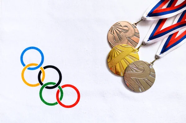Hej, JAPAN og JANUAR. 20. 2020: Medalje sæt, Guld sølv og bronze, hvid baggrund, olympiske cirkler - Stock-foto