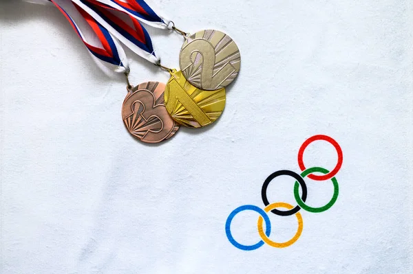 Tokio, Japan, januari. 20. 2020: gouden zilveren en bronzen medaille op witte achtergrond, olympische cirkels — Stockfoto