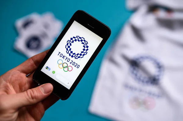 TOKIO, JAPÓN, ENERO. 20. 2020: Smartphone y Tokio 2020 logotipo del juego olímpico de verano. Aplicación olímpica foto conceptual, Azul editar espacio —  Fotos de Stock