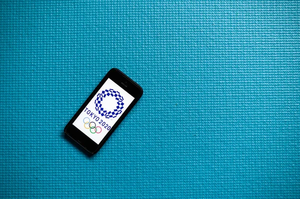 Tokió, Japán, január. 20. 2020: A Xxxii Nyári Olimpiai Játékok 2020 logója mobiltelefon képernyőn. Kék szerkesztési hely — Stock Fotó