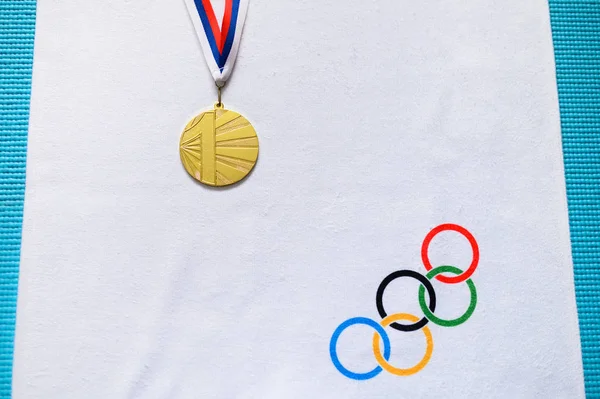 Tokió, Japán, január. 20. 2020: Aranyérem és olimpiai körök fehér alapon — Stock Fotó