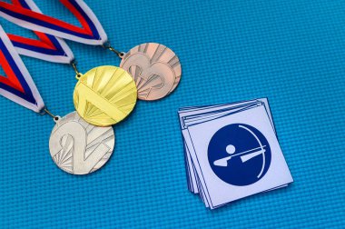 Okçuluk ikonu ve madalya seti, altın gümüş ve bronz madalya, mavi arka plan. Tokyo 2020 Yaz Olimpiyatları için orjinal duvar kâğıdı
