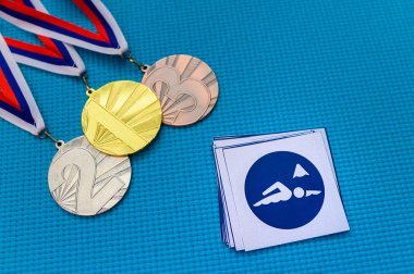 Maraton yüzme ikonu ve madalya seti, altın gümüş ve bronz madalya, mavi arka plan. Tokyo 2020 Yaz Olimpiyatları için orjinal duvar kâğıdı